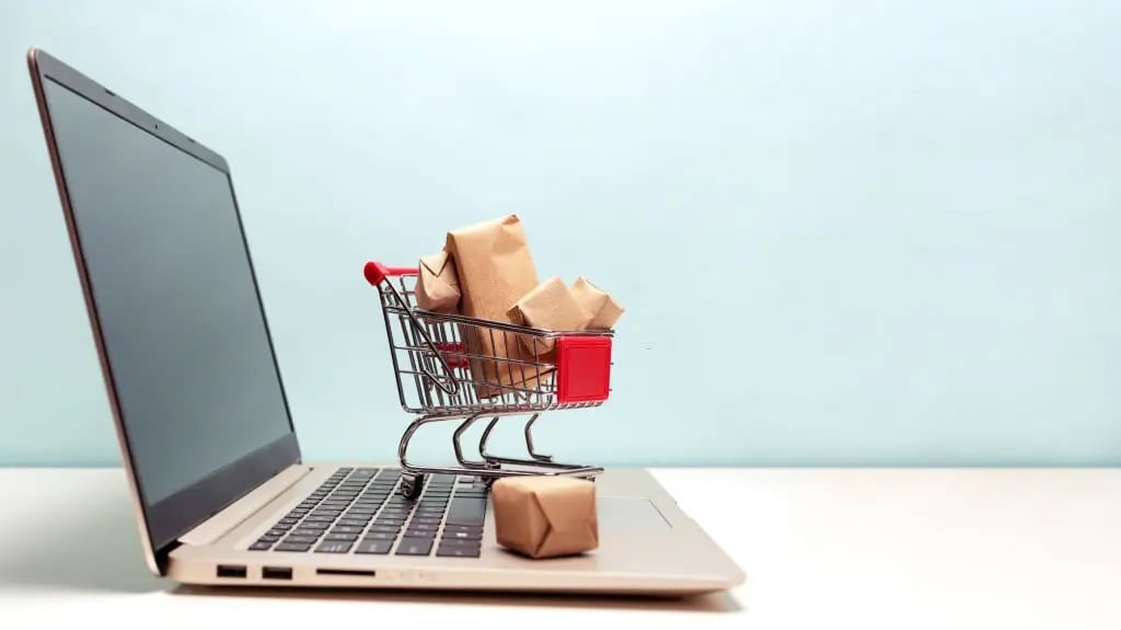 Representacion de ecommerce con un carrito y una laptop.