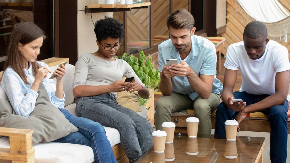 Grupo de personas viendo el telefono.